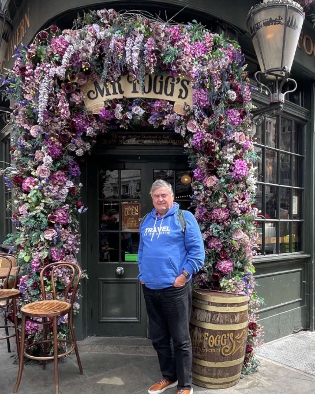 Cos in front of flowered entrance to Mr. Fogg's pub